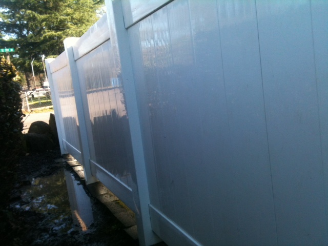 Same wood fence after pressure washing, clean and restored